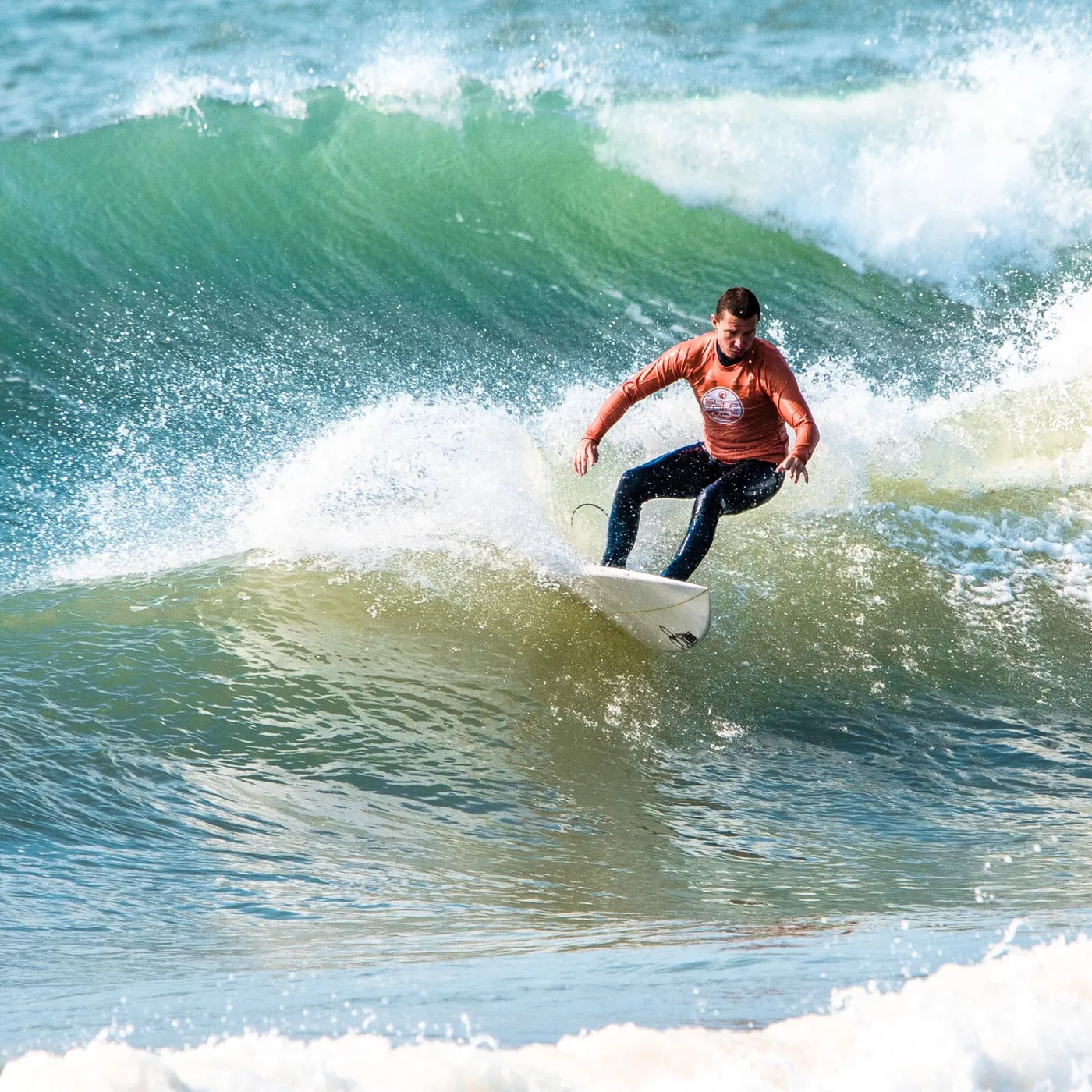 Surfista intermediário na parede da onda