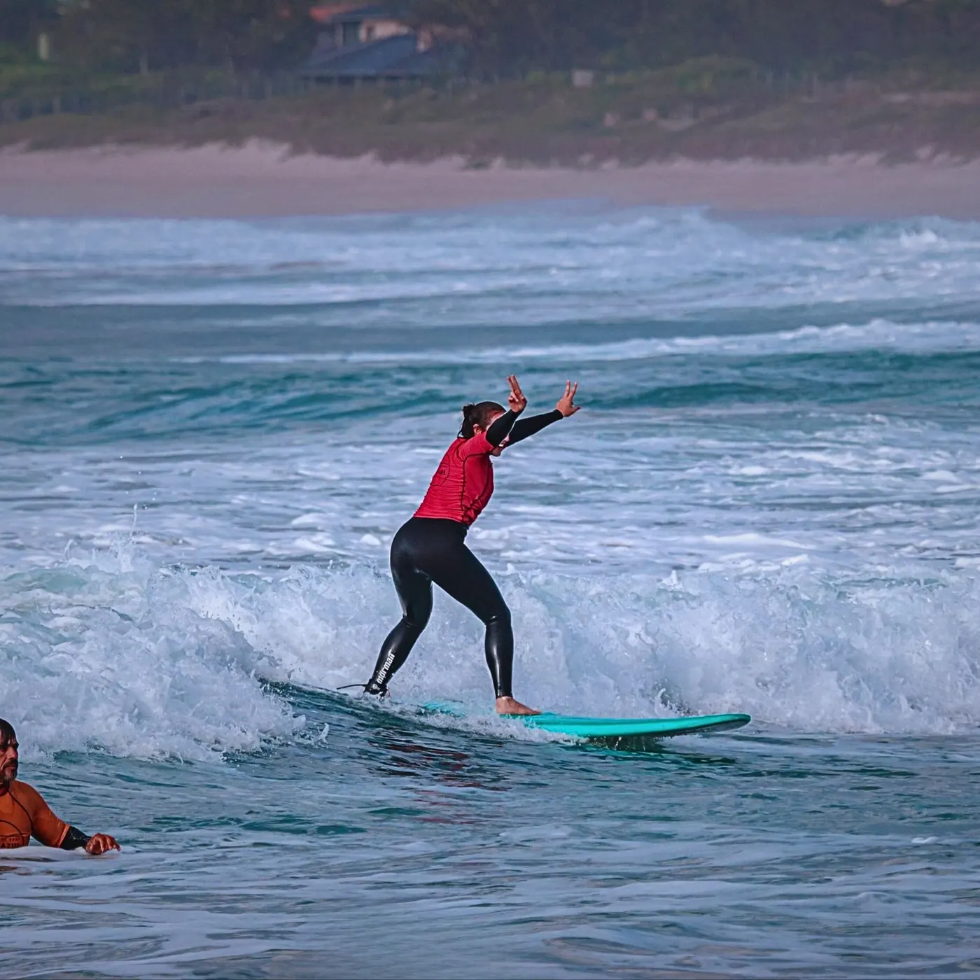 Aluna iniciante surfando